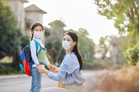 疫情亲情戴口罩的妈妈送女儿上学背景