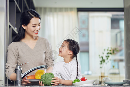 厨房里母女在厨房里一起洗菜的母女背景