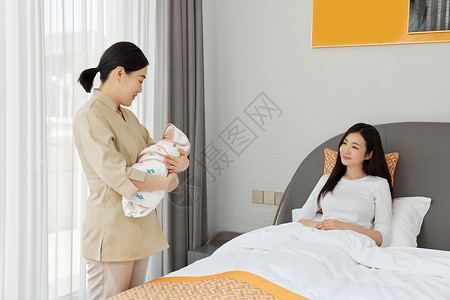 月嫂陪坐月子的母亲照顾新生婴儿关心高清图片素材