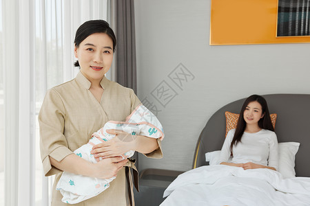 月嫂陪坐月子的母亲照顾新生婴儿互动高清图片素材