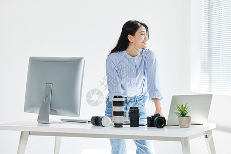 商业青年女摄影师在工作室工作图片