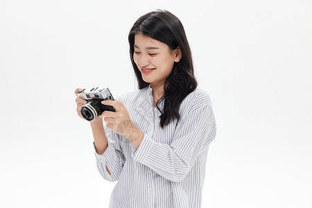 年轻女性使用复古相机拍照背景图片