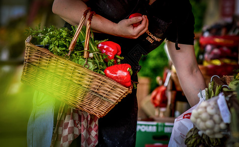 一名妇女提着菜篮在菜市场采购蔬菜xinxian高清图片