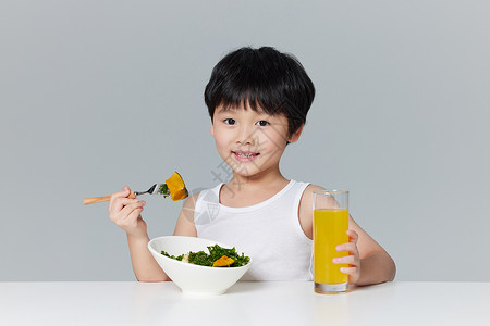 健康小男孩吃沙拉喝果汁图片