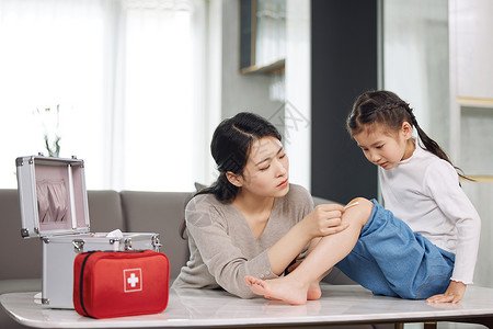 生活常识母亲给受伤的女儿处理伤口背景