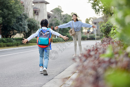 妈妈和小女孩放学回家与母亲拥抱的女儿背景