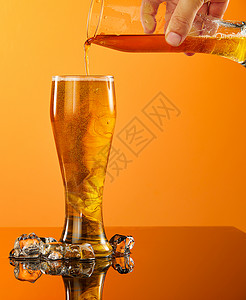 橙色背景前的夏日啤酒饮品图片