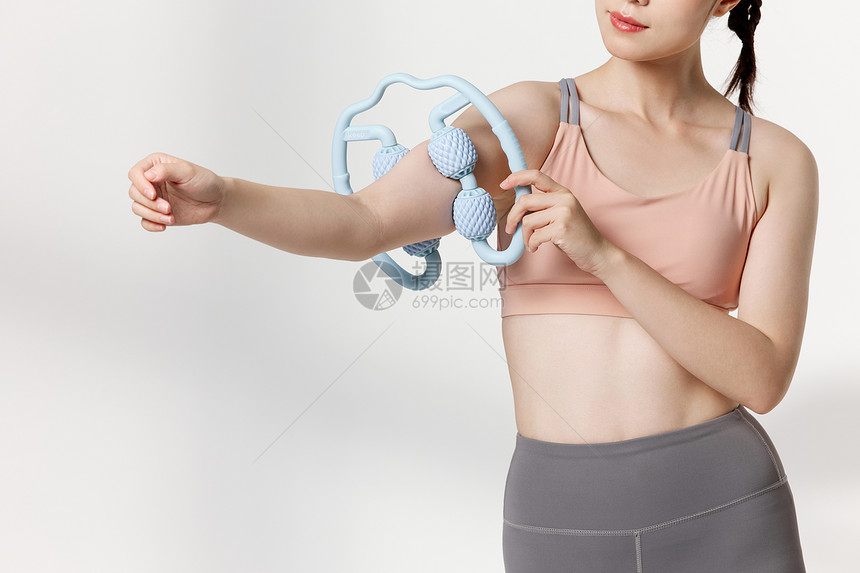 运动后使用器材放松肌肉的青年女性图片