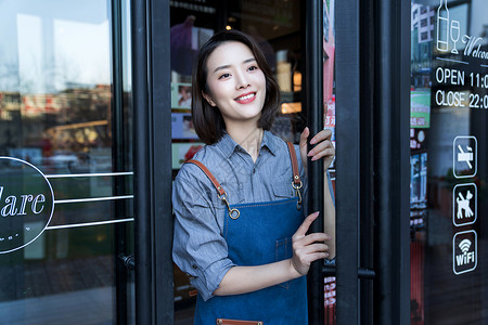站在咖啡店门口的女服务员20多岁高清图片素材