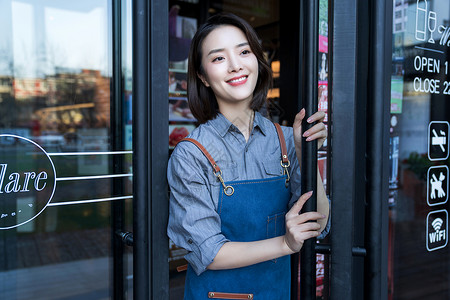 咖啡馆门口站在咖啡店门口的女服务员背景