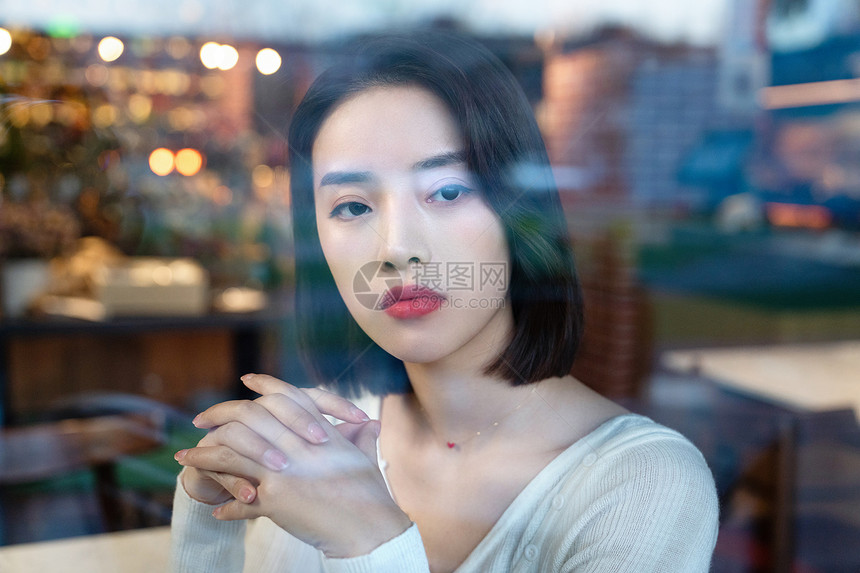 时尚的年轻女人看向窗外图片