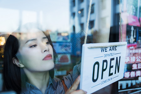 热情海报咖啡店的女服务员挂营业标志背景