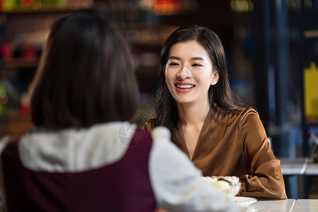 餐吧内聊天的年轻闺蜜两个人高清图片素材