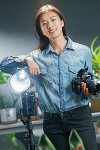 在工作室里的青年女摄影师背景图片