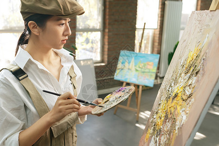 青年艺术家青年女画家在工作室里创作背景