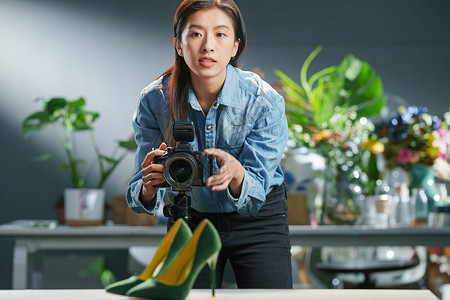鞋子女在工作室里的青年女摄影师背景