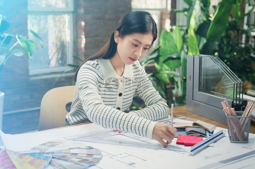 青年女设计师在办公室工作图片