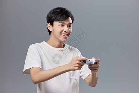 手拿游戏手柄玩游戏的年轻男性背景图片