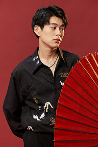 手拿油纸伞的新中式男青年背景图片
