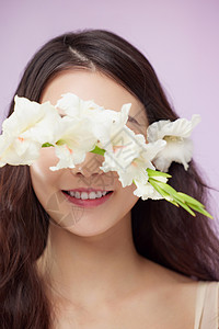 花卉挡住眼睛笑的女性高清图片
