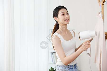 居家女性在家使用手持挂烫机背景