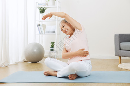瑜伽伸展运动老人在家里做伸展运动背景