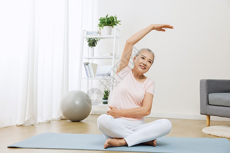 瑜伽伸展运动老年人在家里做伸展运动背景