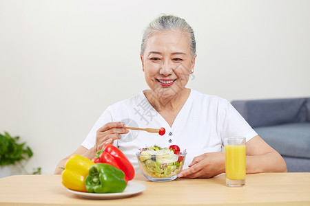 老人美食素材吃水果沙拉的老年女性形象背景