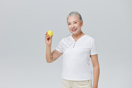 手拿柠檬的老年人背景图片