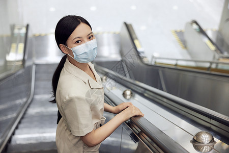 疫情期间女白领乘坐地铁电梯背景图片