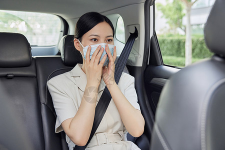 戴口罩乘坐网约车的女白领图片