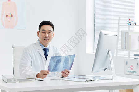 专家在线医疗专家坐在电脑前看x光片背景