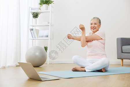 对着电脑做瑜伽的老年人背景图片