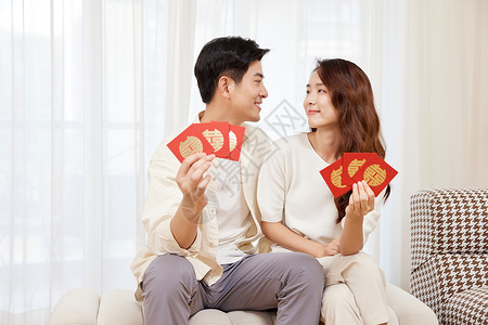 手拿红包感到开心的情侣背景图片
