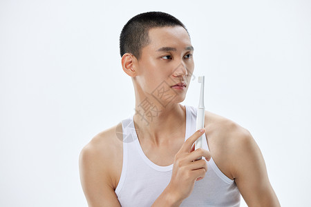 年轻男士展示电动牙刷背景图片