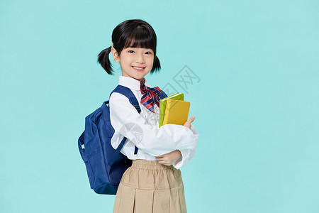 抱着书本背书包上学的小女孩图片