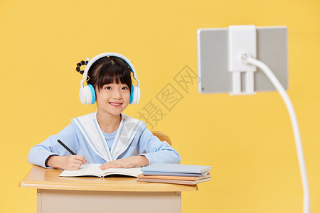 戴着耳机上网课学习的小女生背景图片