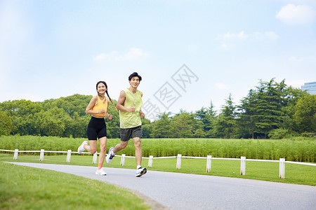 体育公园年轻男女户外跑步运动背景