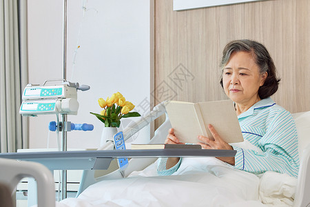 生病住院的老人看书阅读背景图片