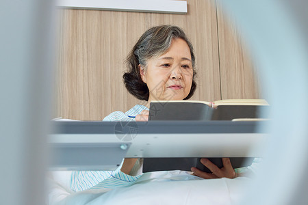 生病住院的老人看书阅读形象图片