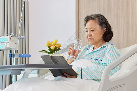 生病住院的老人看书阅读形象背景图片