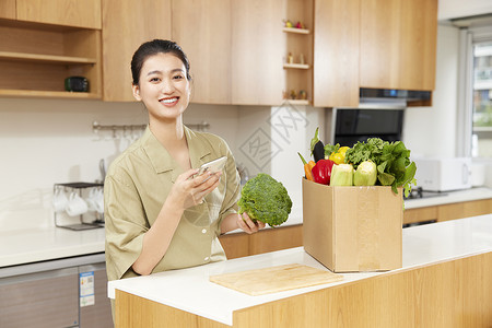 青年女性居家线上团购蔬菜背景图片