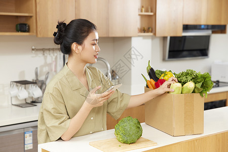 年轻女性检查团购蔬菜质量背景图片