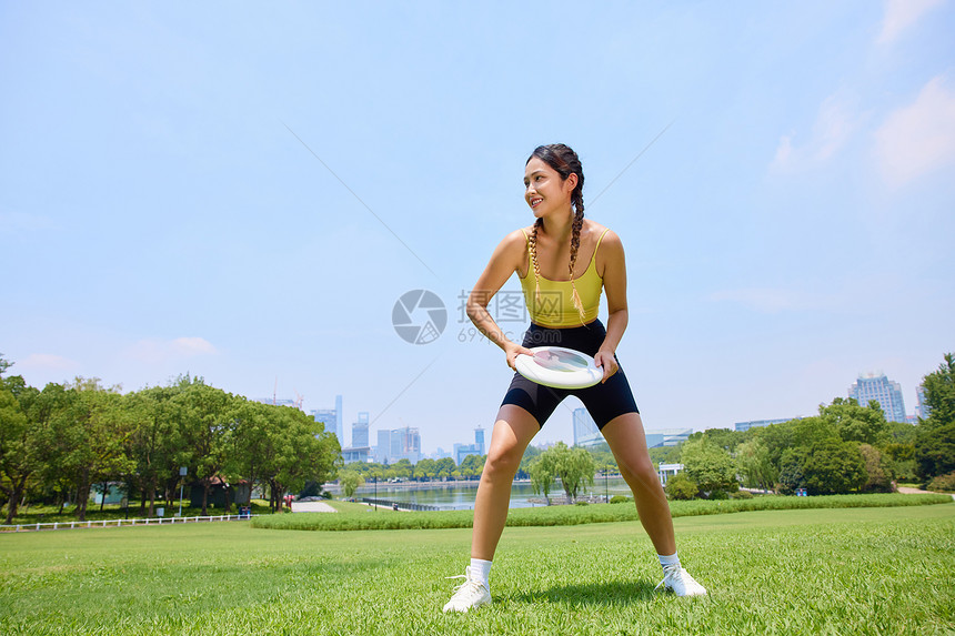 户外玩飞盘运动的年轻美女图片