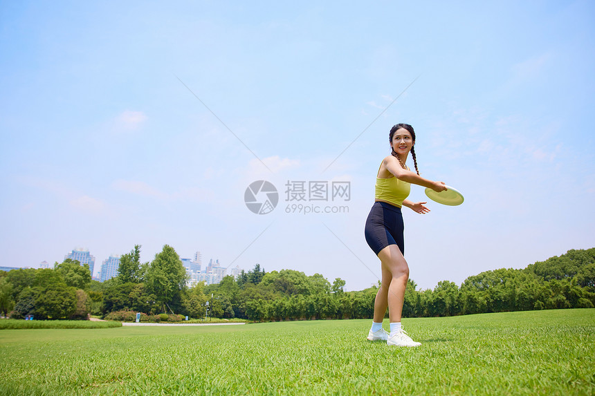 年轻美女在户外玩飞盘运动图片