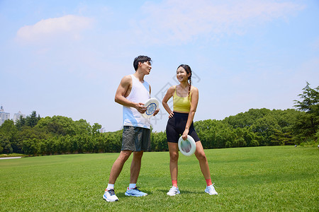 年轻男女户外飞盘运动图片