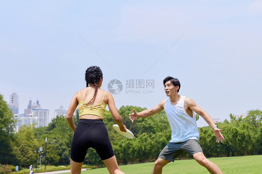 青年男女户外玩飞盘图片