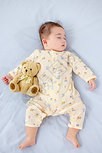 抱着玩偶睡觉的可爱宝宝背景图片