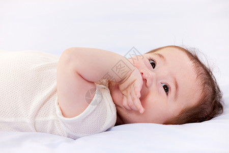 躺在床上吃手的可爱宝宝高清图片