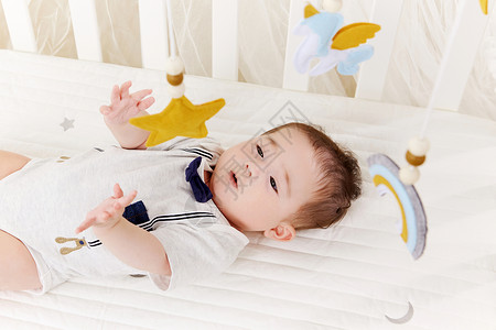 宝宝在婴儿床上玩床铃图片